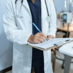 doctor writing on a clipboard