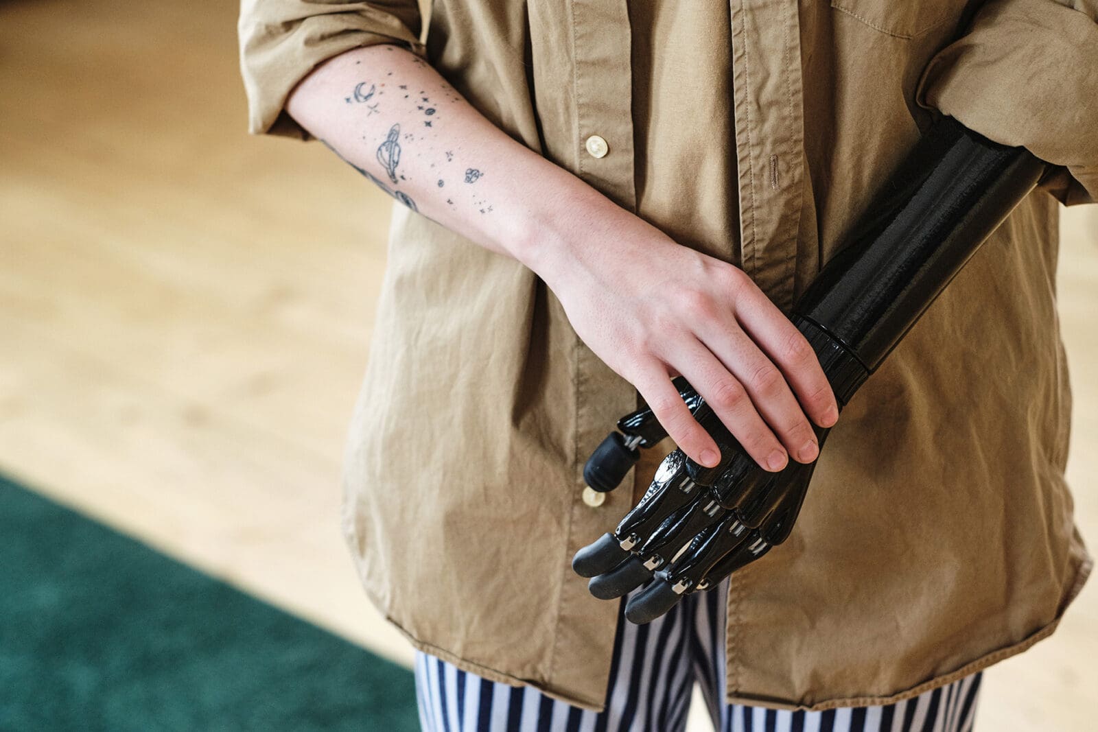 Close-up of young woman in shirt having prosthetic arm instead of amputee arm