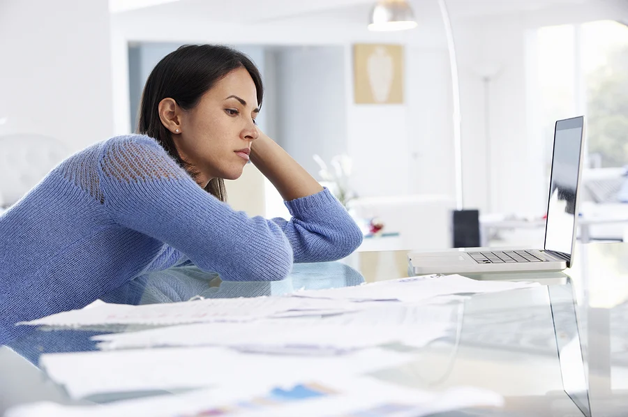 Stressed veteran surrounded by paperwork trying to understand why her VA claim was denied