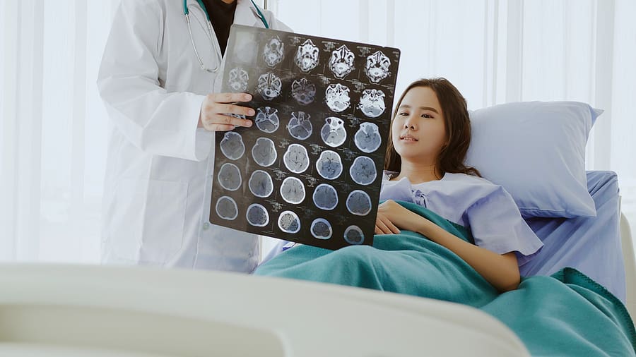 Doctor speaking to veteran about her brain cancer scans in a hospital room