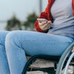 veteran in a wheelchair looking up the 2024 va pay chart on her phone