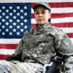 female veteran in a wheelchair in front of a flag receiving disability benefits due to the benefit of the doubt doctrine